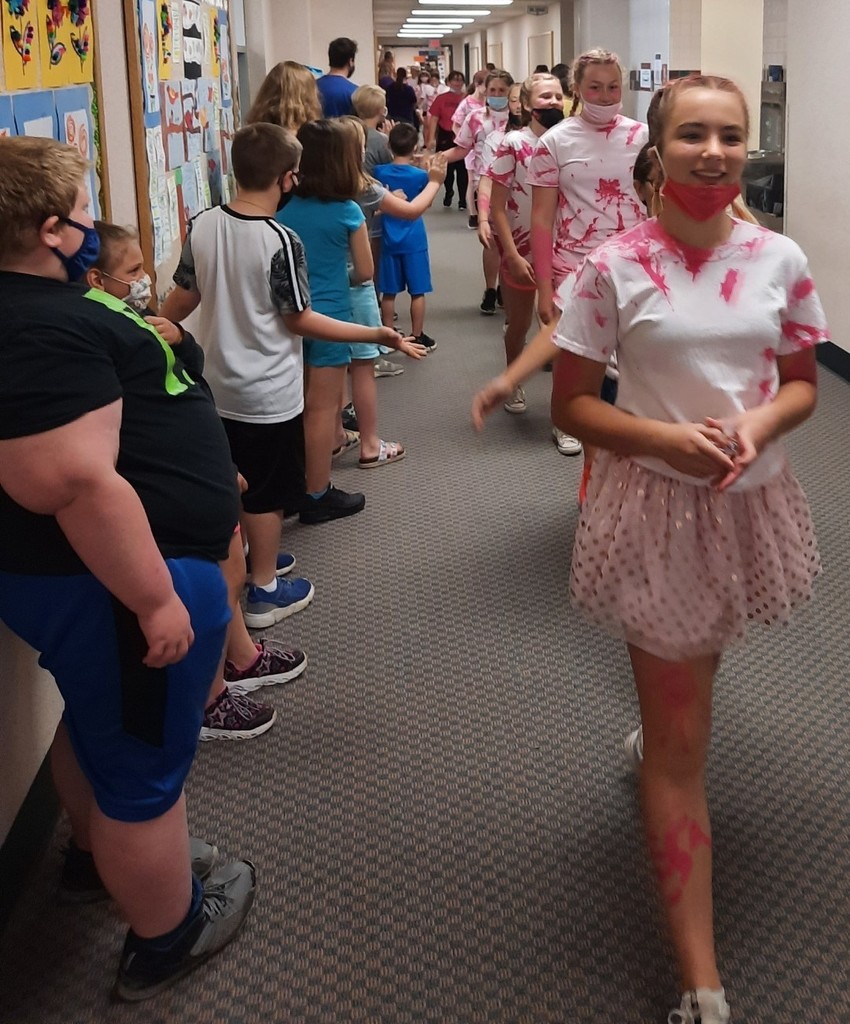 Students congratulate 6th graders marching down hall