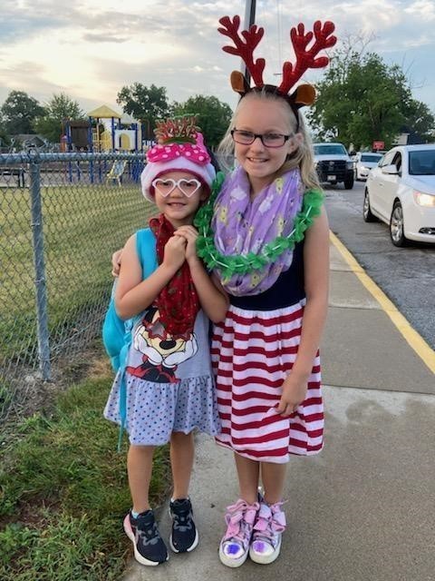 two elementary girls dressed up like Christmas