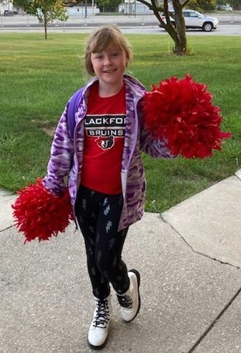 Girl dressed in spirit gear with pompoms