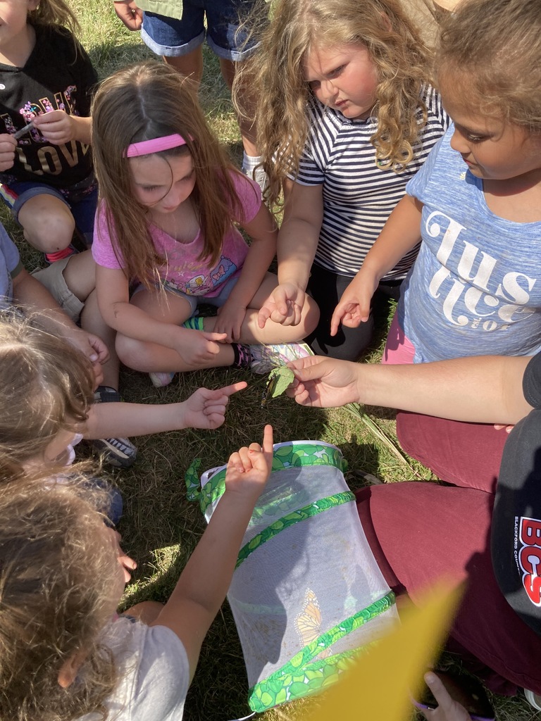 Kindergarten students gather to hold a butterfly