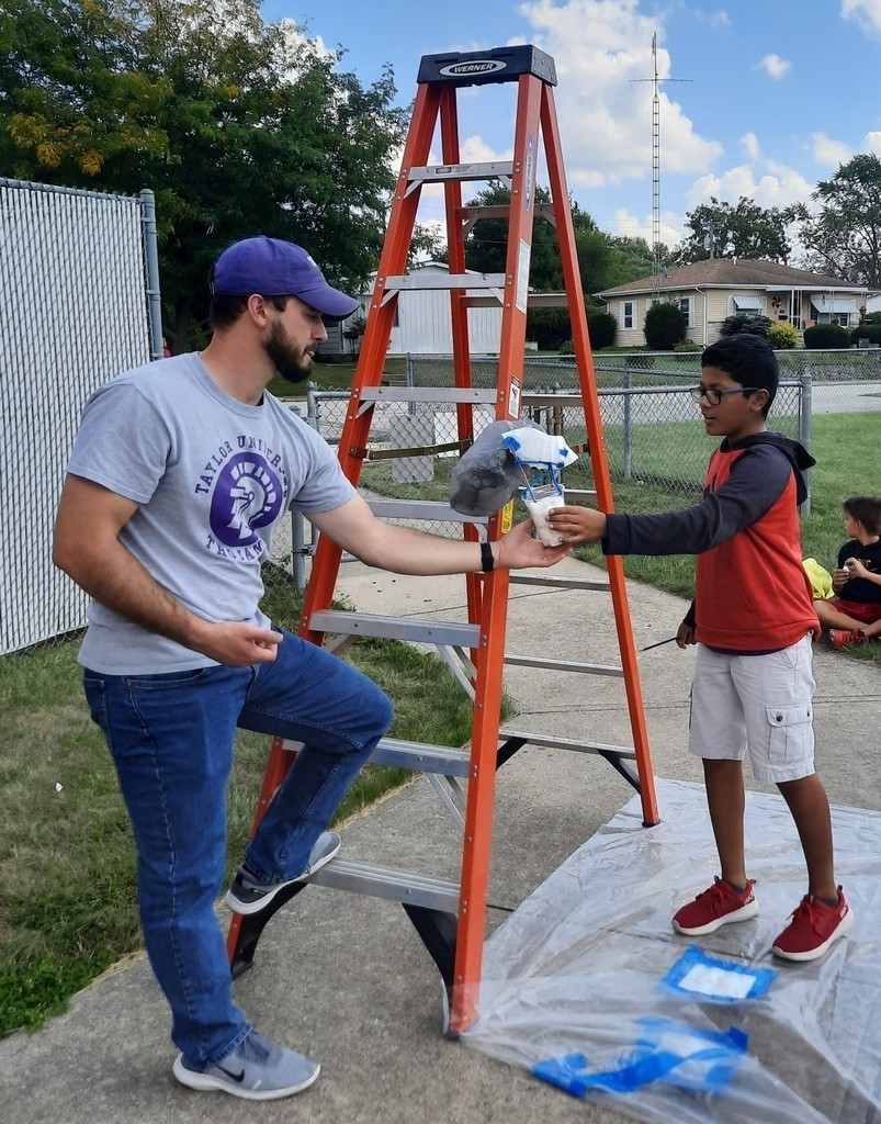 A boy gives his egg to the teacher for the drop