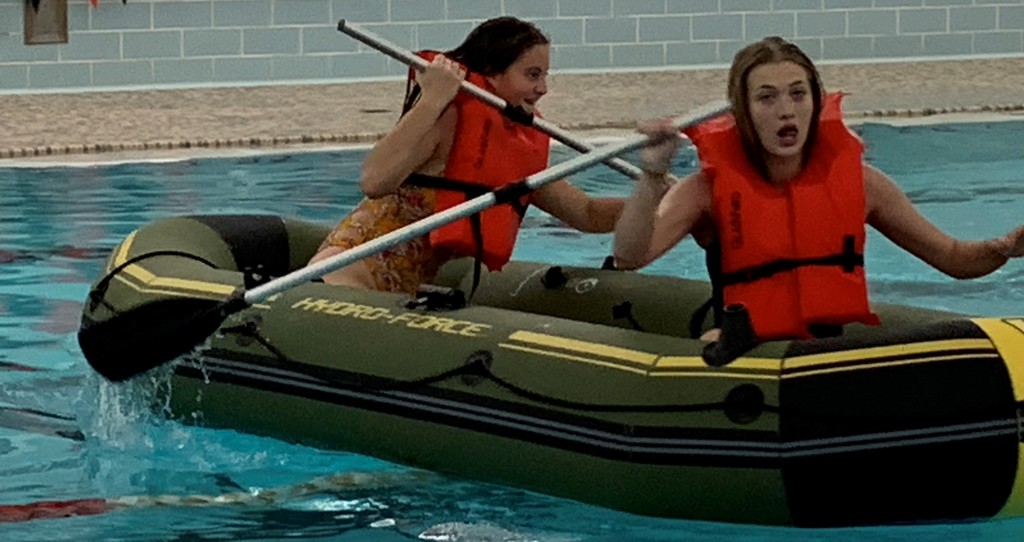 2 girls row a raft in the BJSHS pool