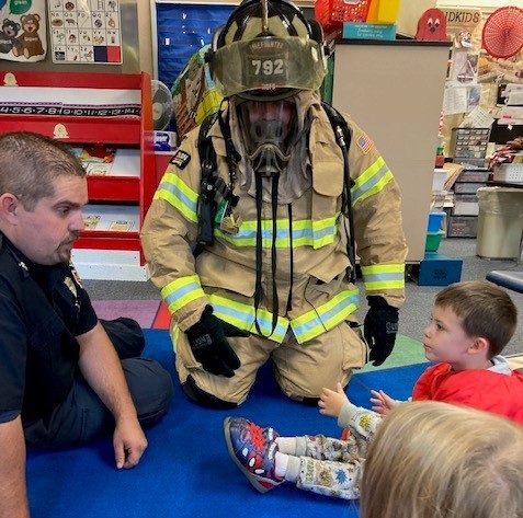 Fireman demonstrates protective gear for students