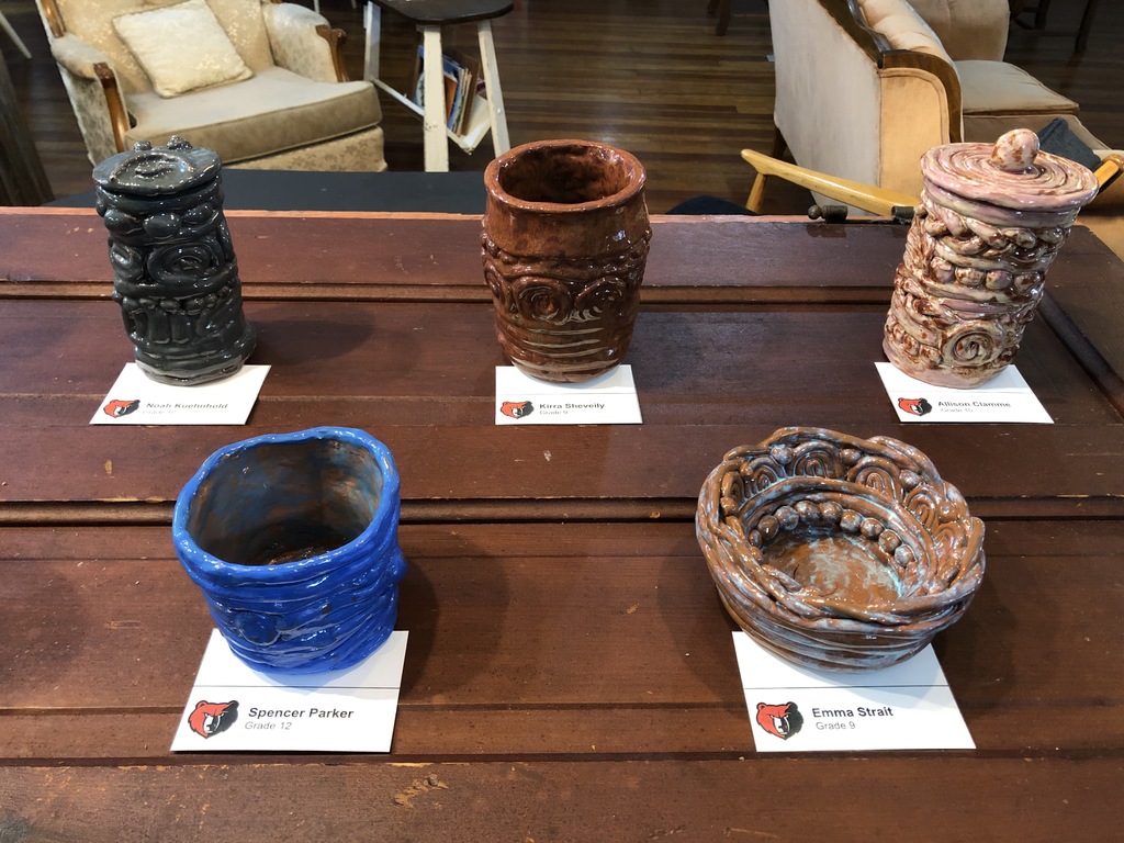 5 pieces of pottery being displayed on a table