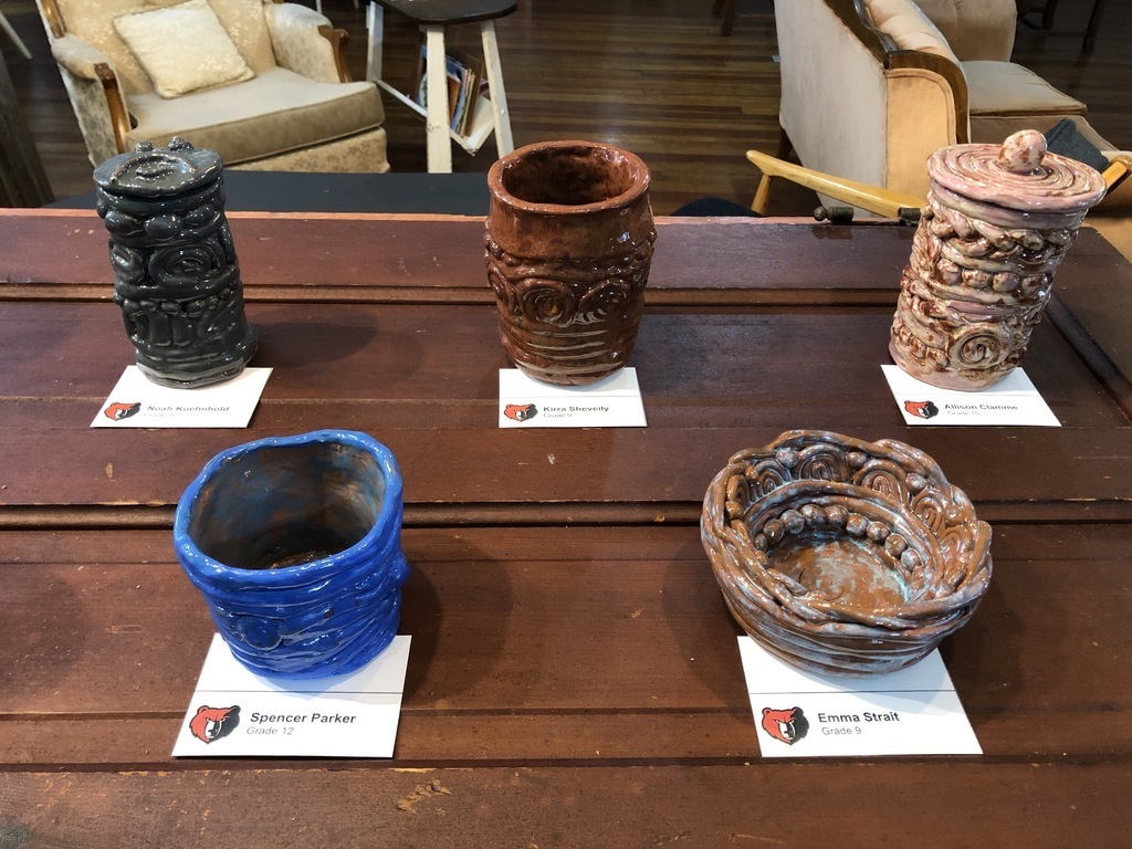5 pieces of pottery being displayed on a table