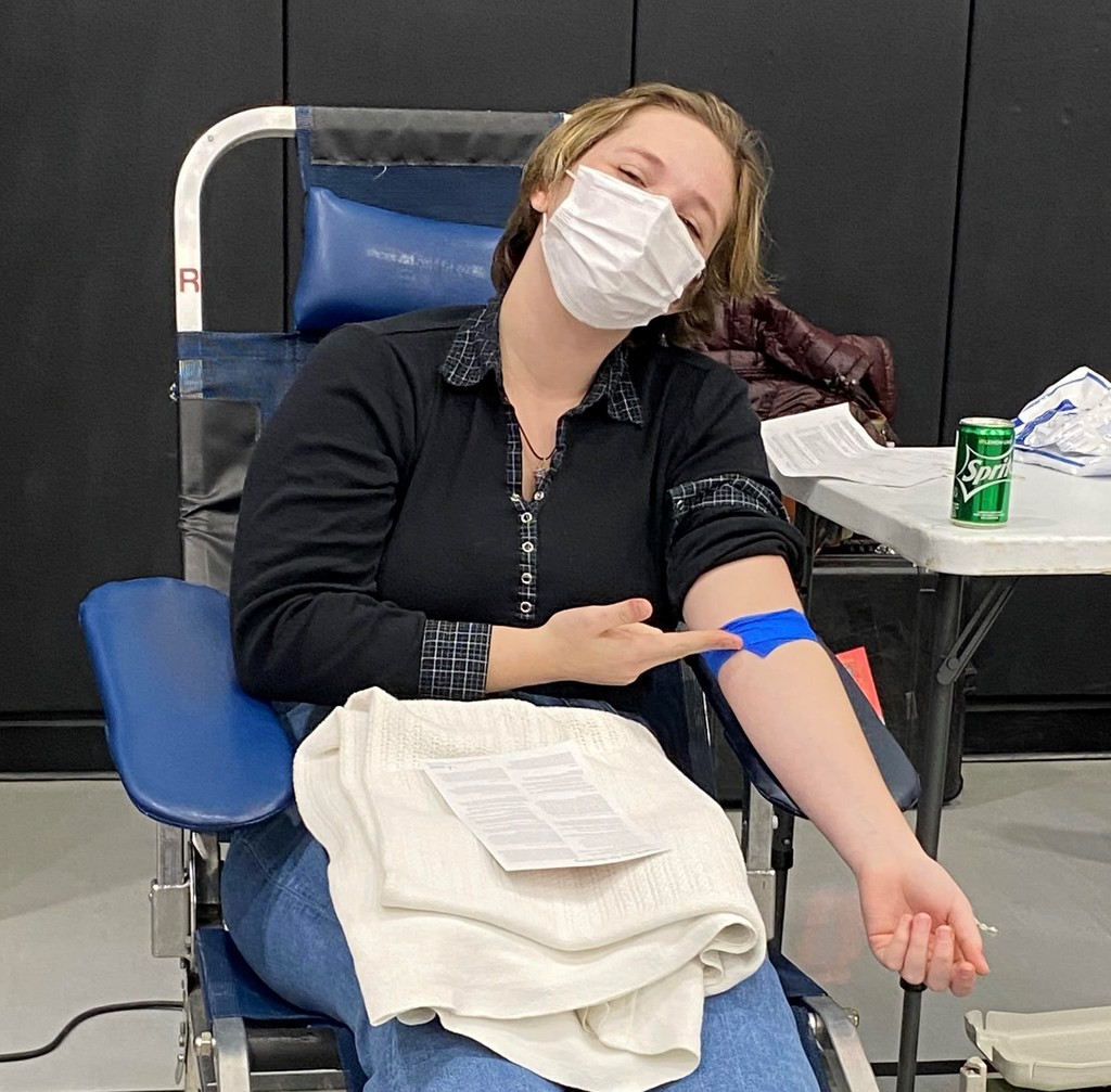 Boy points to bandage after donating blood