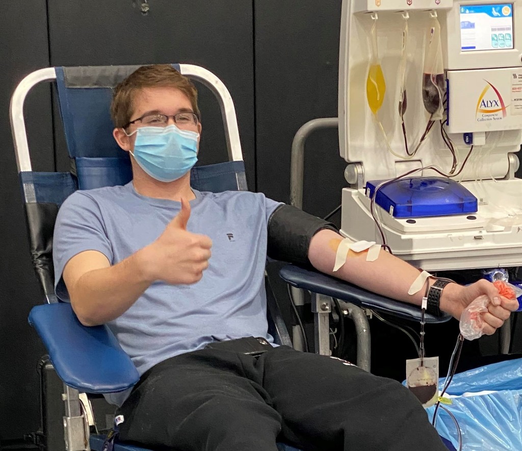 Boy gives thumbs up after donating blood