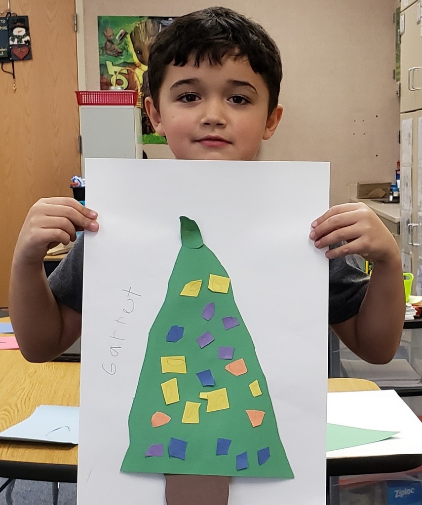 Boy holds a Christmas tree he made