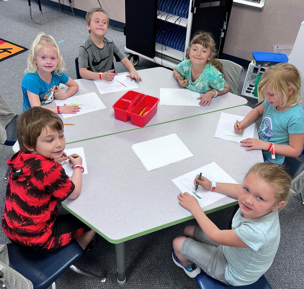 Kindergarten boys and girls sitting at table