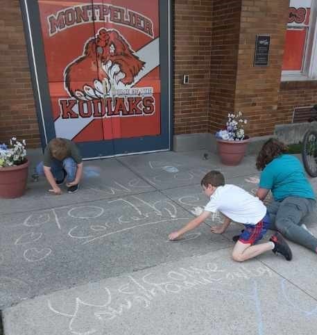 Kids drawing with sidewalk chalk