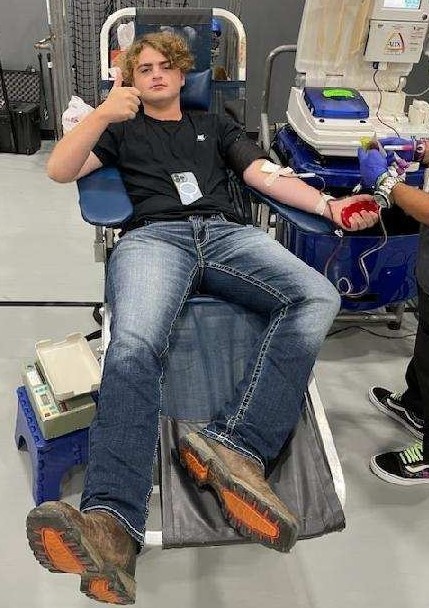 Male student donates blood at HOSA drive