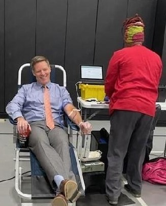 Assistant Supe David Parker donates blood at HOSA drive