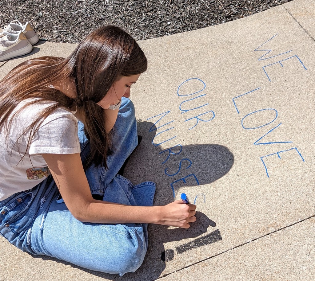 Student makes a chalk message for nurses