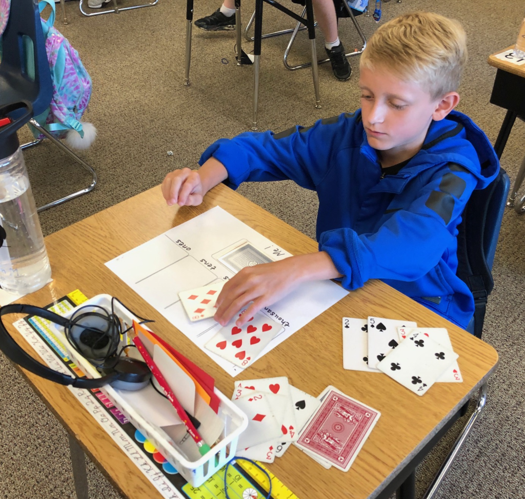 Boy placing cards on a worksheet